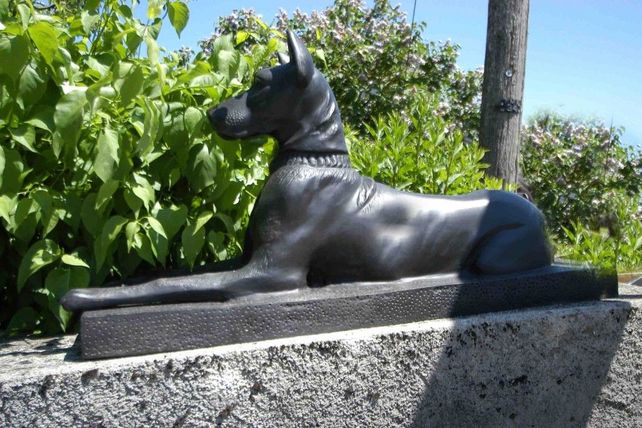 Bronzefigur eines liegenden Dobermanns