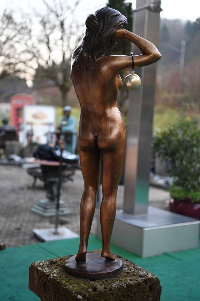 Rückseite einer weibliche Aktfigur aus Bronze mit hinter dem Kopf verschränkten Armen