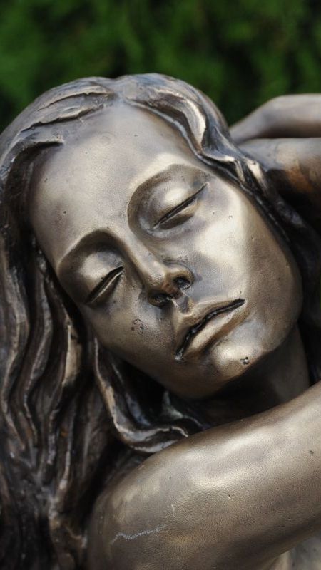 Detailaufnahme einer weiblichen Aktfigur aus Bronze mit geschlossenen Augen