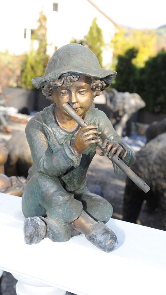Sitzende Bronzefigur eines kleinen Jungens