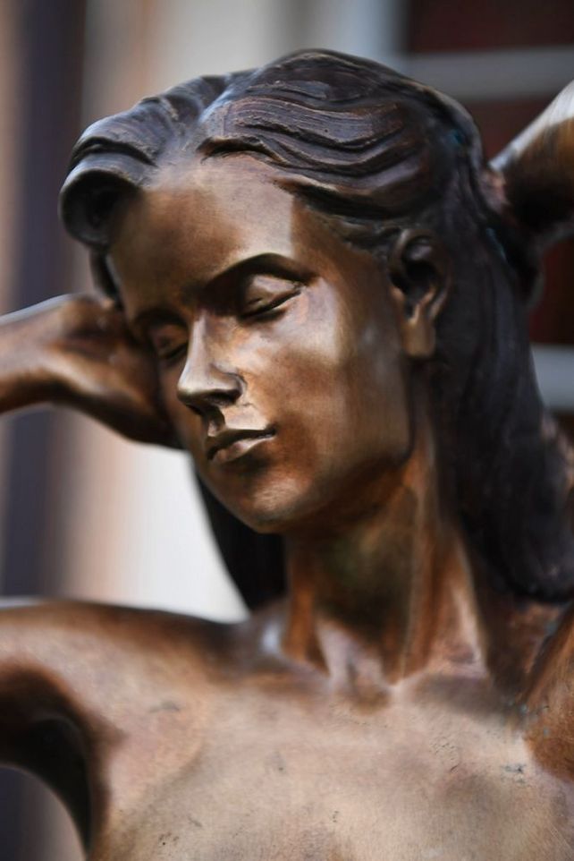 Detailaufnahme einer weiblichen Aktfigur aus Bronze mit geschlossenen Augen