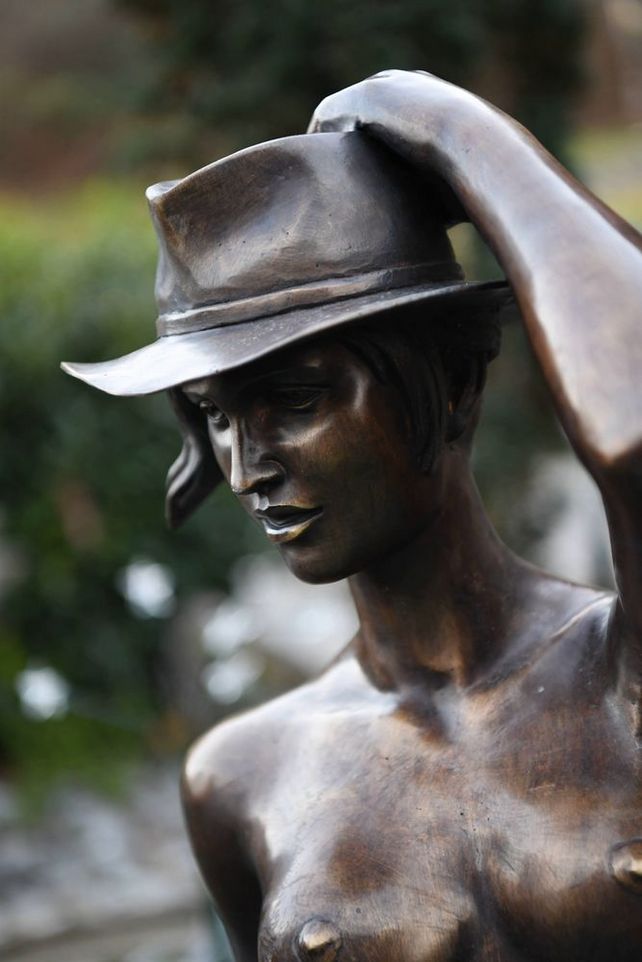 Detailaufnahme einer weiblichen Aktfigur aus Bronze mit Hut