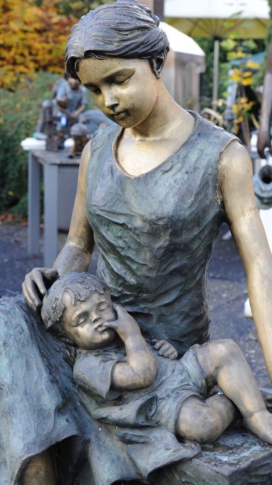 Bronzefigur einer Mutter mit einem Kind auf dem Schoss