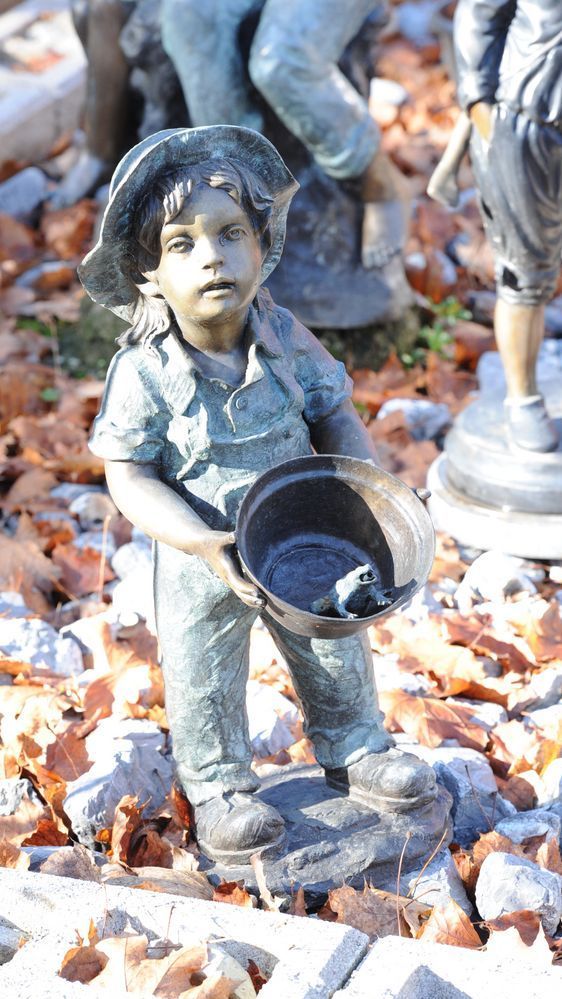 Bronzefigur von einem kleinen Kind mit Topf und Frosch