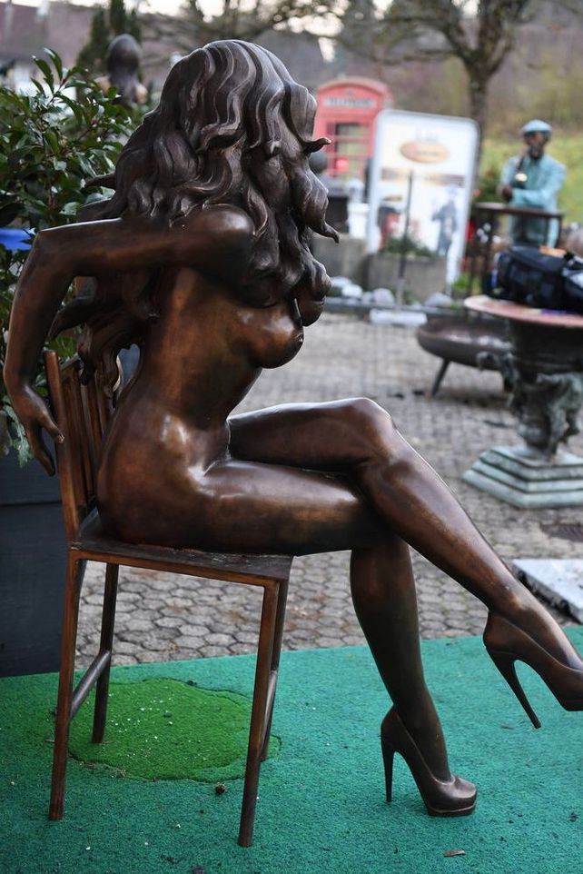 Weibliche Aktfigur aus Bronze auf Stuhl sitzend