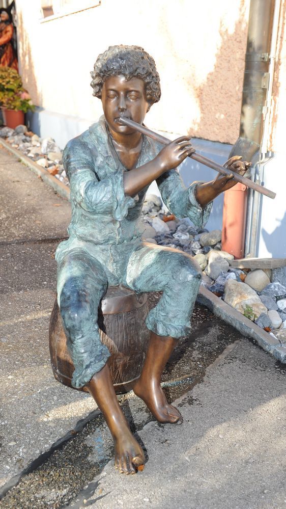 Bronzeskulptur von sitzendem Flötenspieler
