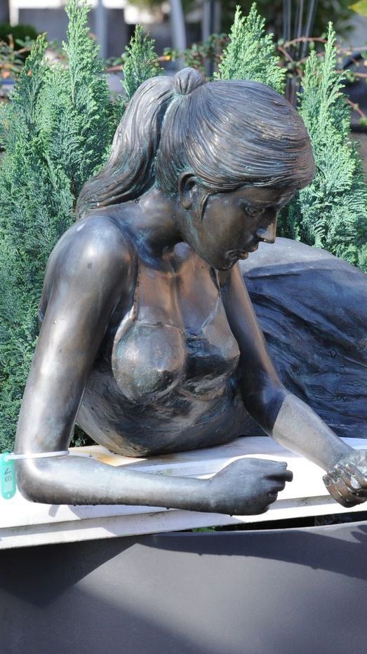 Liegende Bronzefigur einer erstaunten jungen Frau