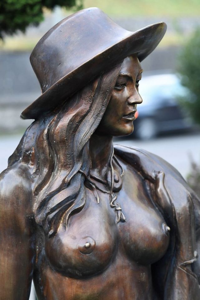 Weibliche Bronzefigur von stehendem Aktmodell mit Cowboyhut und Fokus aufs Gesicht