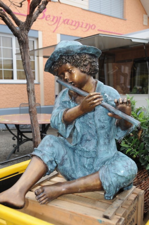 Sitzende Bronzeskulptur von Flötenspieler mit Hut