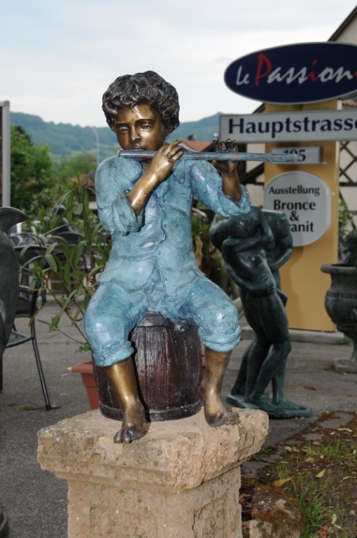 Bronzeskulptur sitzender Junge mit Flöte auf Fass